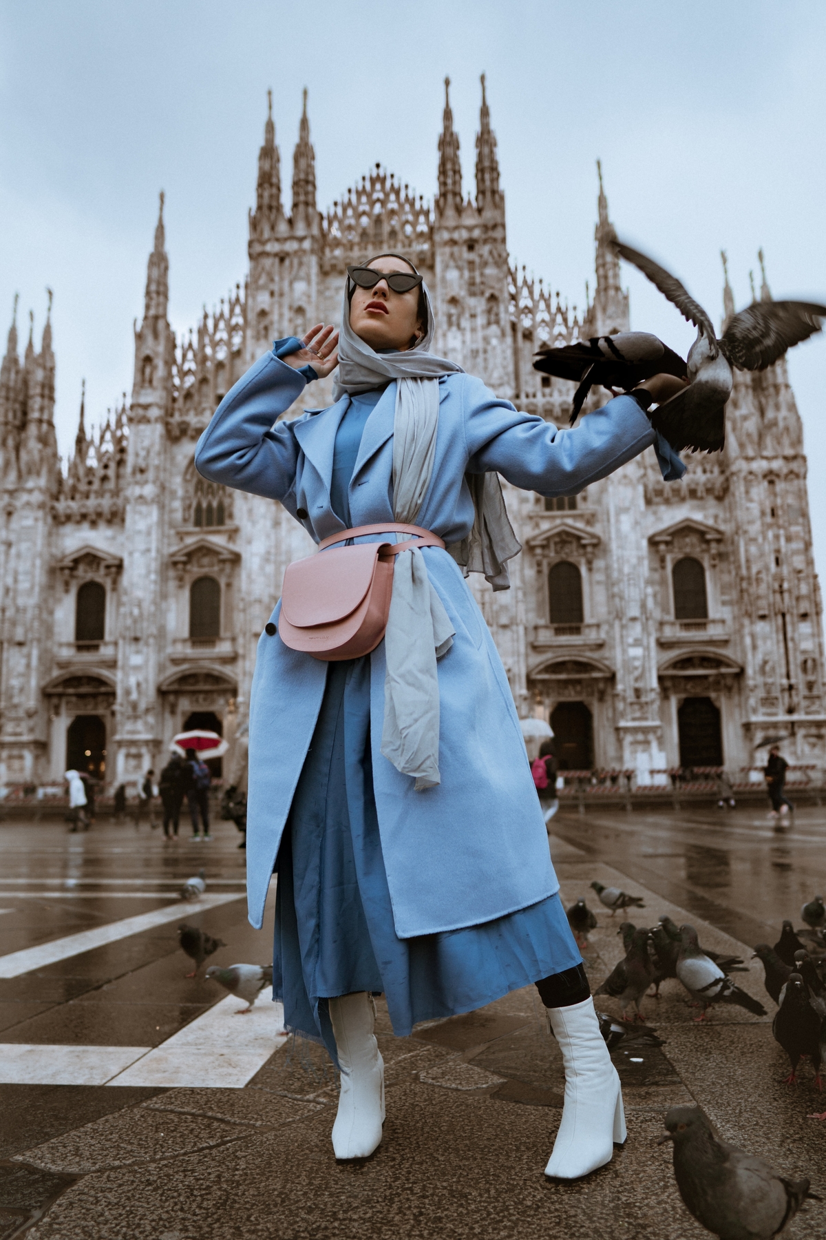mladá žena v modrom kabáte na námestí v Miláne